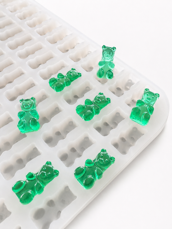 Stampo per caramelle gommose a orsetto da 1.5 mL - 296 cavità - primo piano angolato, con caramelle gommose verde smeraldo, traslucide