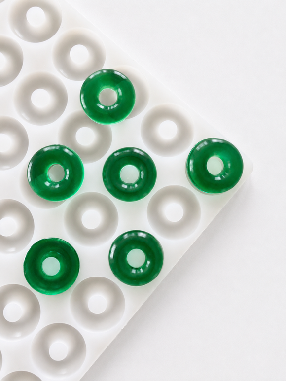 Stampo per caramelle gommose ad anello di pesca da 3.4 mL - 108 cavità - vista angolata, con caramelle gommose verde smeraldo, traslucide