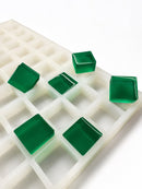 Stampo per caramelle gommose quadrate da 6 mL, 165 cavità — vista laterale angolata; gummies quadrate traslucide verde smeraldo; sfondo bianco