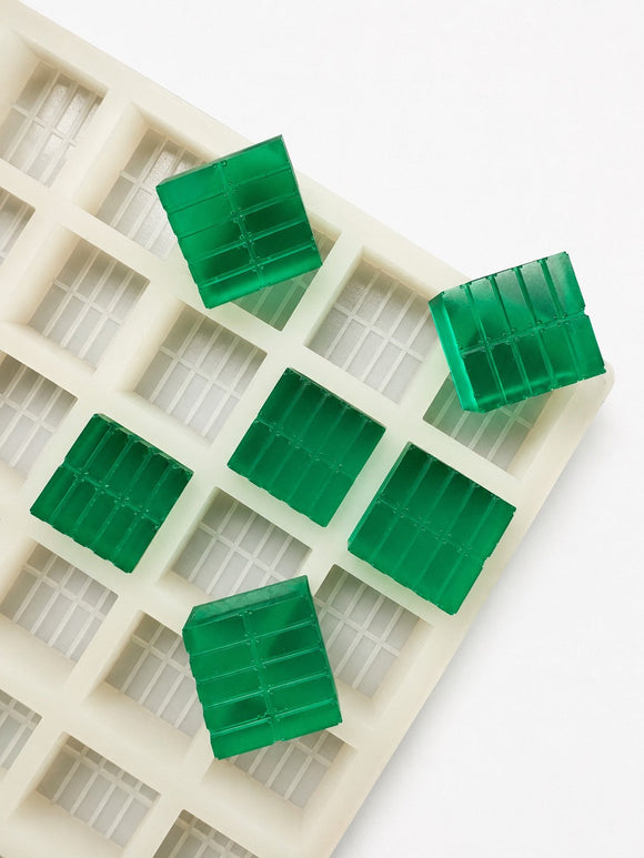 Top view of a 7.4mL brick gummy mold with 70 cavities and emerald green brick gummies on a white background